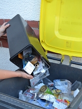 Aus einem kleinen Behälter wird Plastik- und Dosenmüll in die Gelbe Tonne gekippt. © Universitätsstadt Marburg